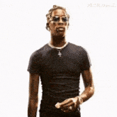 a man wearing sunglasses and a cross necklace holds a piece of food in his hand