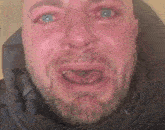 a close up of a man 's face with tears coming out of his eyes