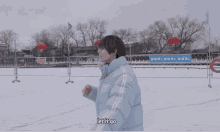 a person wearing a jacket that says nerdy stands in the snow with their arms outstretched