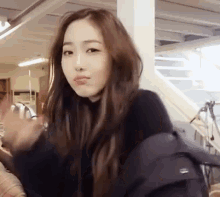 a woman with long brown hair is wearing a black sweater and a black jacket .