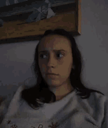 a woman is making a funny face while sitting on a couch .