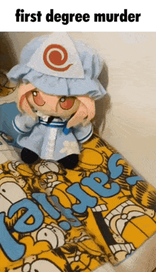 a stuffed animal is sitting on top of a bed with a blanket that says first degree murder .