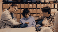 a woman wearing a zebra print shirt sits at a table with a man and a girl
