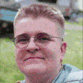 a woman wearing glasses and a blue shirt looks at the camera
