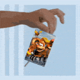 a hand is holding a picture of donkey kong on a stick
