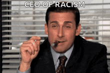 a man in a suit and tie is smoking a cigar with the words ceo of racism above him
