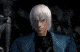 a man with gray hair and a blue jacket stands in a dark room
