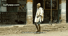 a man is standing in front of a building with the words i 'm getting the hell out of here