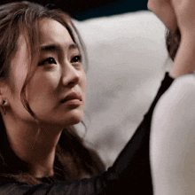 a close up of a woman 's face with a man touching her face