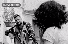 a black and white photo of a man and a woman dancing together .