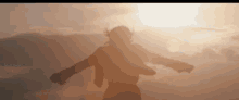 a silhouette of a person with their arms outstretched in front of the sun .