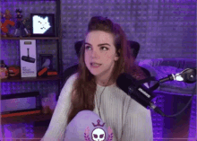 a woman sitting in front of a shure microphone in a purple room