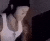a blurry picture of a person wearing a hat and a tank top .