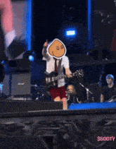a man playing a guitar with a cartoon face on his head and the words $booty on the bottom