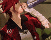 a woman in a red jacket is drinking from a bottle