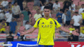 a soccer player wearing a kafd jersey stands on the field