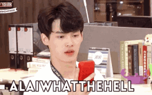 a man holding a red cell phone with the words " alaiwhatthehell " written on the bottom