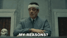 a man with a bandage on his head is sitting at a table and says my reasons