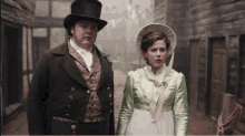 a man in a top hat and a woman in a green dress