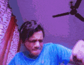 a man wearing a blue shirt is making a funny face