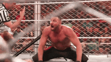 a shirtless wrestler is kneeling down in a ring with his mouth open