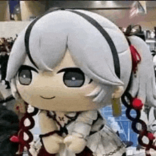 a stuffed toy of a girl with gray hair and pigtails is sitting in a room .