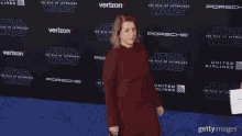a woman stands in front of a star wars carpet