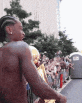a man without a shirt is holding a trophy in front of a crowd of people
