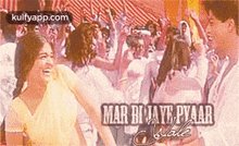 a woman is laughing in front of a crowd of people in a movie poster .