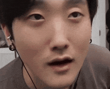 a close up of a man 's face with earbuds on