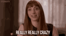 a woman with long red hair and bangs is smiling and saying `` really really crazy '' .