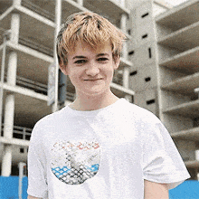 a young boy wearing a white t-shirt with a picture of a cd on it