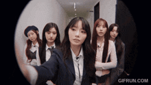 a group of girls are standing in a hallway with a gifrun.com watermark