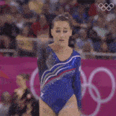 a gymnast performs a trick in front of a crowd at the london olympics