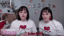 two women wearing white shirts that say dynamite twins are standing next to each other