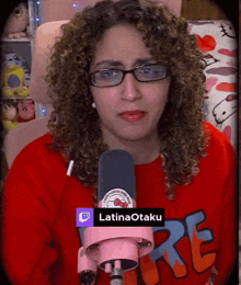 a woman with curly hair is wearing glasses and a hello kitty sweatshirt with the word re on it
