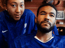 a man with a beard wearing a blue nike shirt