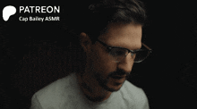 a man wearing glasses is smiling in front of a black background that says patreon