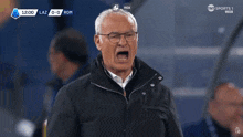 a man wearing glasses is yelling at someone during a soccer match