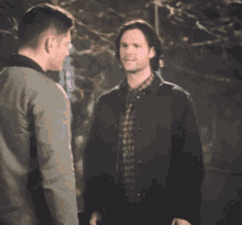 two men are standing next to each other and one of them is pointing at the other