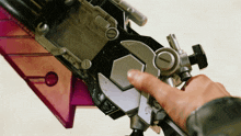 a close up of a person 's hand holding a toy with a purple wing