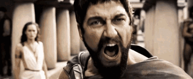 a man with a beard is screaming with a woman in the background