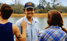 a man wearing a hat that says ' fox ' on it is smiling