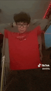 a boy wearing glasses and a red shirt has a tiktok account