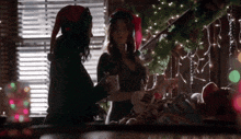 a woman wearing an elf hat is standing next to another woman