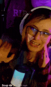 a woman wearing glasses and headphones looks at the camera with the words soup 22h ago on the bottom right