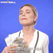 a woman is holding a bunch of money in her hands and says i am rich my dear