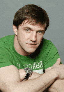 a man is wearing a green shirt that says abercrombie on it