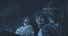 a man and a woman in a dark room looking at something