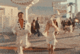 a man and a woman are walking down a street in front of a sign that says ice cream parlor